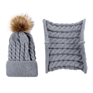 Detailed knit pattern of gray winter hat and scarf set with brown faux fur pompom