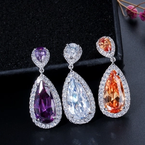 Macro shot of pear-cut teardrop earrings in purple, white, and orange cubic zirconia