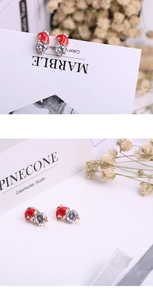 Detail of Christmas snowman hat earrings with red enamel and sparkling zircon crystal
