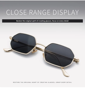 Close-up detail of hexagonal gold metal frames and dark lenses of the retro sunglasses