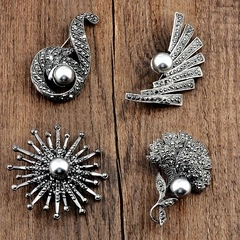 Macro detail of four vintage silver marcasite brooches on a dark wooden surface