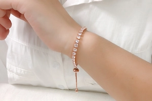 Close-up of a 4mm rose gold tennis bracelet with clear crystals on a woman wrist