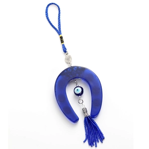 Close-up of Turkish evil eye horseshoe pendant with blue beads and decorative tassel