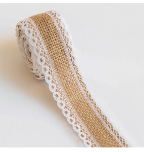 Detail of natural burlap lace ribbon roll showing white floral patterns and rustic fiber texture