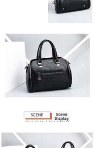 Detailed view of black soft leather handbag featuring metal studs and sturdy dual handles