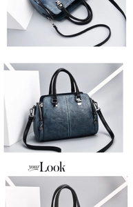 Close-up of blue leather handbag with black handles and high-quality metal hardware