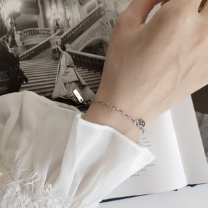 Minimalist S925 sterling silver chain bracelet with a smiley face pendant worn on wrist