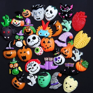 Halloween resin DIY charms set with pumpkin, ghost and bat motifs on black background