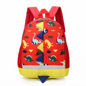 Red toddler dinosaur backpack with colorful patterns and 3D blue horns on white background