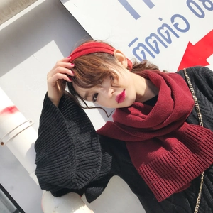 Detail view of red knitted scarf and matching headband set on a model in sunlight
