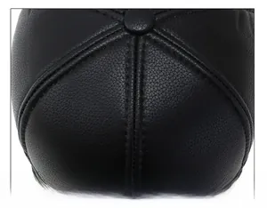 Detail of the litchi texture PU leather crown and stitching on the black winter baseball cap