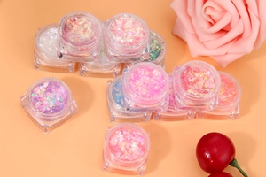 Macro shot of colorful holographic glitter gel jars for body and nail art with rose