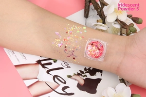 Detailed swatch of Iridescent Powder 05 with heart and star glitters on skin
