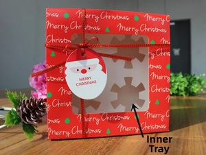 Detail of red Christmas cupcake box with window, festive ribbon, and internal tray
