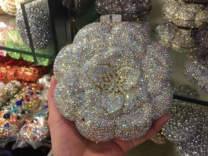 Detailed macro view of colorful rhinestone flower evening bag with metallic floral center