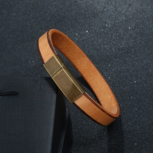 Detail of brown leather bracelet with stitched edges and bronze magnetic metal clasp