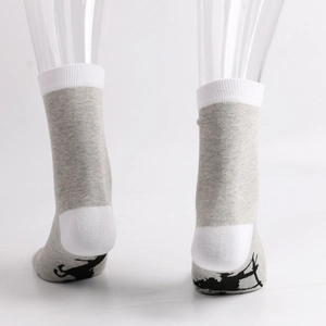Detail view of cotton crew socks featuring a black reindeer silhouette pattern on the sole