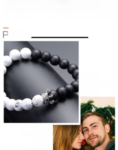 Detail view of 8mm white turquoise and matte black bead bracelet with silver crown charm