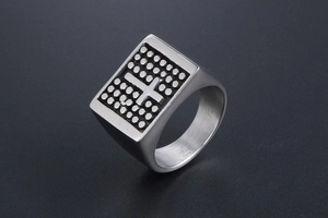 Detail view of vintage stainless steel signet ring with engraved cross pattern