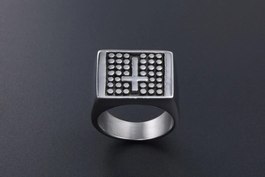 Macro view of vintage signet ring with embossed dots and inverted cross detail