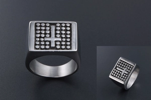 Macro detail of men's vintage steel signet ring featuring cross pattern and textured dots