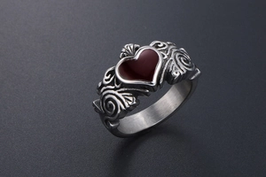 Detail of a silver Claddagh ring featuring a deep red heart stone and intricate engravings