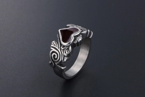 Detailed macro view of silver steel ring featuring red enamel heart and embossed patterns