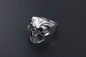 Detailed 45-degree angle view of a stainless steel skull ring with gothic carved details