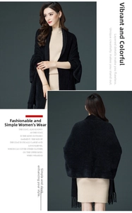 Detail of plush black knit shawl featuring elegant fringe tassels and longline texture