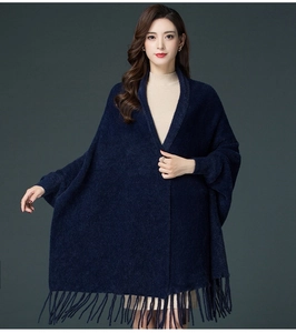 Detail of dark blue knitted shawl with fringe hem and premium faux mink fur texture