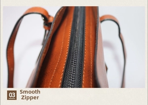 Gros plan d'une fermeture éclair fluide et du cuir texturé d'un sac cabas vintage