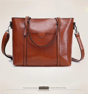 Sac fourre-tout marron foncé montrant la texture du cuir et la conception des anses