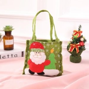 Sacchetto regalo di Natale verde con Babbo Natale 3D su un tavolo decorato
