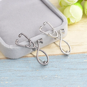 Set of two metal stethoscope brooches in silver and gun-black finish displayed on box