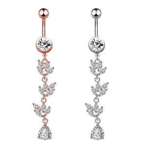 Detail of rose gold and silver navel rings featuring leaf-shaped zircon dangles
