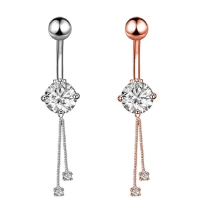 Detailed view of silver and rose gold belly rings with zircons and hanging chains