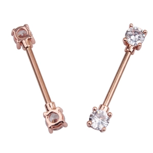Macro detail of rose gold nipple rings featuring clear cubic zirconia stones on both ends