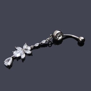 Detailed view of a silver belly ring with flower and teardrop zircon on a grey surface