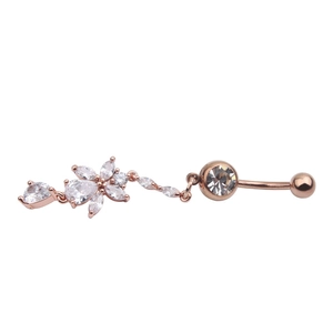 Close-up of rose gold belly button ring with sparkling flower pendant and zircon stones