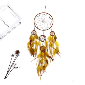 Close-up of brown dreamcatcher with handmade woven webs, colorful beads and feathers