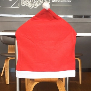 Detail of red Santa hat chair cover with white plush trim for Christmas table decor