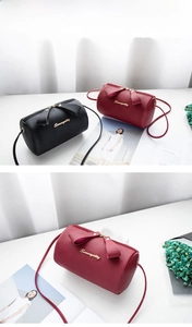 Detail of burgundy mini boston bag featuring lychee grain leather and bow zipper pull