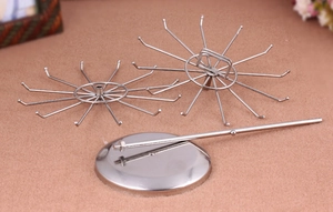 Disassembled view of vintage iron jewelry stand with rotating racks and a round base