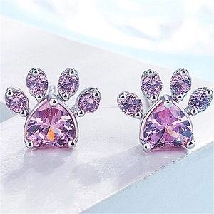 Macro shot of paw-shaped stud earrings with pink heart-shaped crystals and rose gold plating