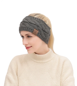 Detail of dark grey knit headband with classic cable pattern and brown C.C leather patch