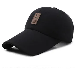 Detailed side view of black cotton baseball cap with vintage brown leather patch