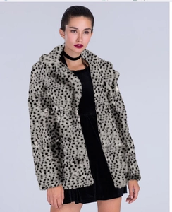 Detail of faux fur leopard coat featuring black and white spotted plush texture