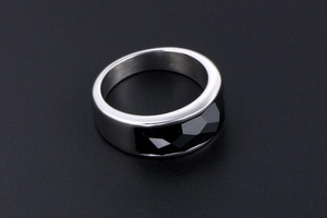 Macro shot of bridge-style stainless steel ring featuring a faceted black rectangle gem