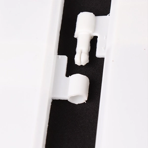 Close-up of white plastic fence connector components for Christmas tree borders