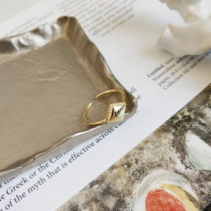 Detail of adjustable 925 sterling silver ring with golden geometric rhombus design